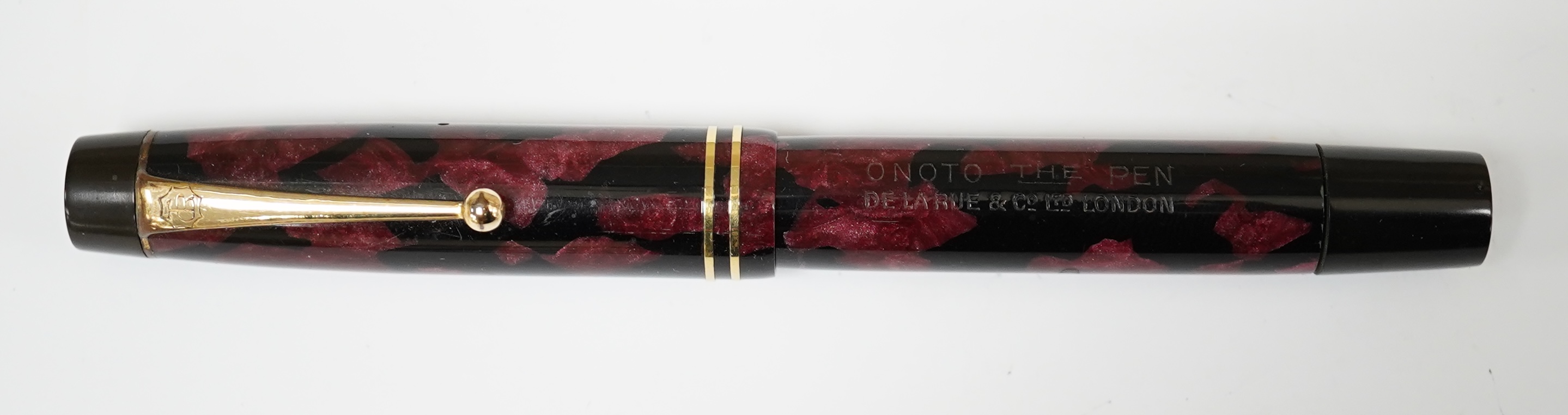 A De La Rue Onoto black and red marble piston filler with 14ct. gold No.4 nib